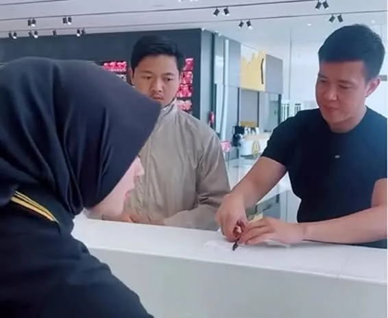 Seorang pemuda (tengah) sedang mendapat gratisan di depan Mbak Kasir toko '*&R'. Pemilik toko (kanan) menandatangani struk gratisan. Pemuda tadi bertanya-tanya, mengapa ada orang tetiba datang dan melakukan itu. (Foto: google)