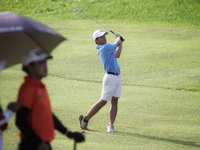 Pegolf Kota Surabaya William Justin Wijaya (kanan) saat memukul bola di fairway hole 8 Araya Golf Course, Malang, dalam hari kedua cabor golf Porprov IX Jatim 2025. (Foto: PGI Jatim)