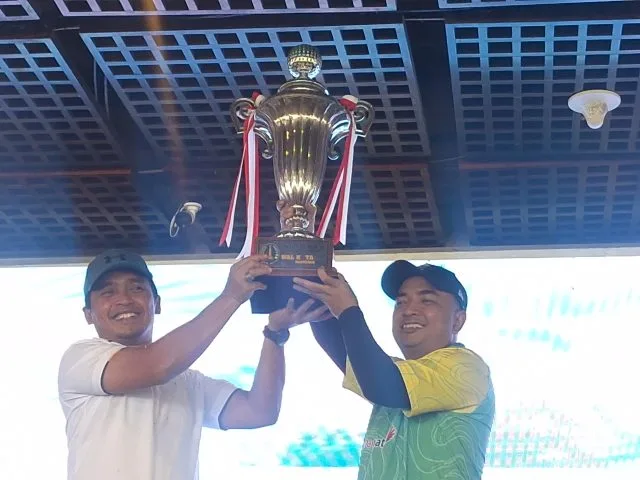 Walikota Pasuruan Adi Wibowo (kiri) dan pemenang Best Gross Overall Noor Akhmad Trimayuda (kanan) mengangkat piala bergilir Turnamen Golf Piala Walikota Pasuruan di Taman Dayu Golf Club & Resort, Pasuruan. (Foto: Istimewa)
