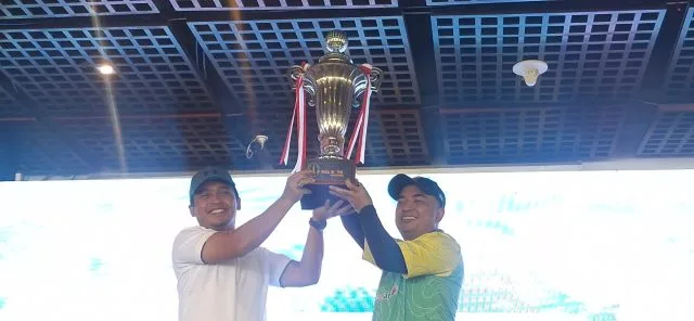 Walikota Pasuruan Adi Wibowo (kiri) dan pemenang Best Gross Overall Noor Akhmad Trimayuda (kanan) mengangkat piala bergilir Turnamen Golf Piala Walikota Pasuruan di Taman Dayu Golf Club & Resort, Pasuruan. (Foto: Istimewa)